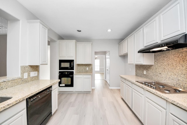 6803 Chapelfield Ln, Houston, TX 77049 - kitchen with black appliances, under cabinet range hood, white cabinetry, decorative backsplash, and light wood finished floors