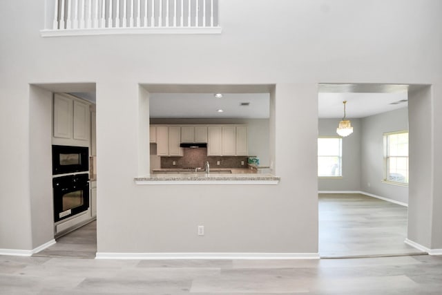 6803 Chapelfield Ln, Houston, TX 77049 - kitchen featuring black appliances, light wood-style floors, under cabinet range hood, tasteful backsplash, and recessed lighting