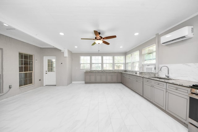 6803 Chapelfield Ln, Houston, TX 77049 - kitchen with gray cabinetry, a wall mounted air conditioner, ceiling fan, recessed lighting, and light stone counters