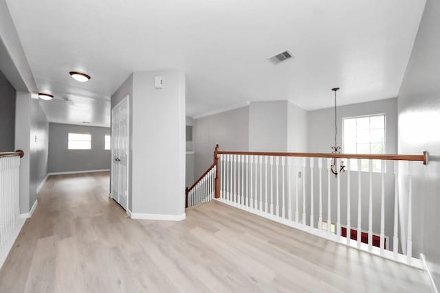 6803 Chapelfield Ln, Houston, TX 77049 - hallway featuring wood finished floors, an upstairs landing, and a chandelier