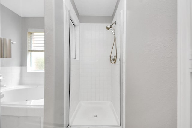 6803 Chapelfield Ln, Houston, TX 77049 - full bathroom featuring a stall shower, a bath, and a textured wall