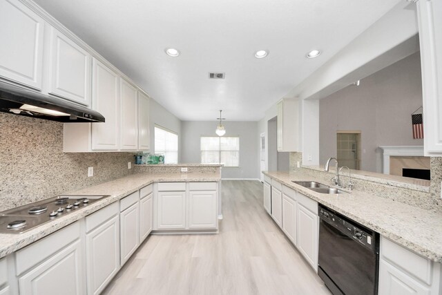6803 Chapelfield Ln, Houston, TX 77049 - kitchen featuring black dishwasher, stainless steel cooktop, a peninsula, white cabinets, and light wood finished floors