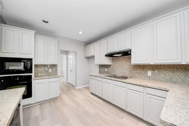6803 Chapelfield Ln, Houston, TX 77049 - kitchen with black appliances, white cabinetry, light wood-type flooring, under cabinet range hood, and decorative backsplash