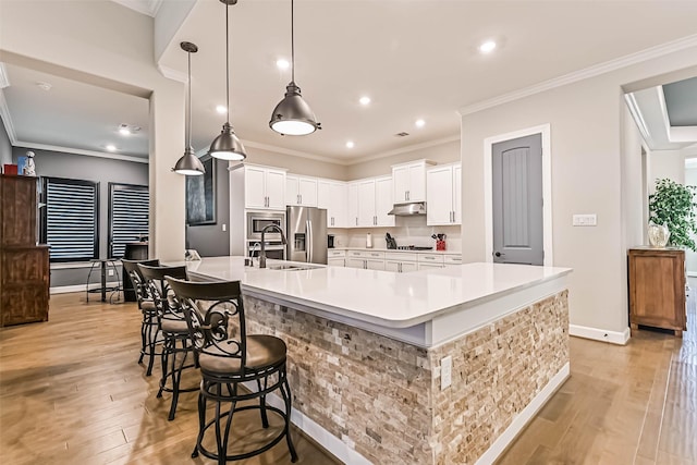 1939 Heather Canyon Dr, Pearland, TX 77089 - kitchen featuring stainless steel appliances, a breakfast bar area, light wood finished floors, light countertops, and recessed lighting