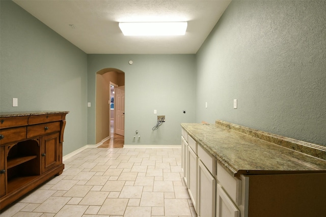 6709 Jay Rd, Hitchcock, TX 77563 - laundry area featuring electric dryer hookup, arched walkways, washer hookup, and cabinet space