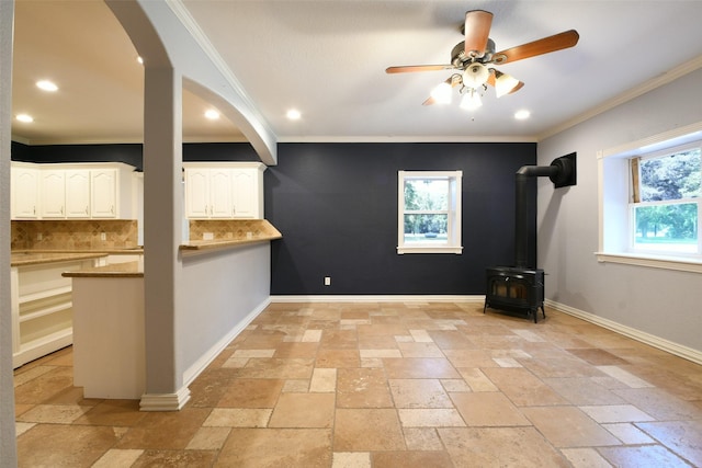 6709 Jay Rd, Hitchcock, TX 77563 - empty room featuring stone tile floors, ceiling fan, crown molding, recessed lighting, and a wood stove