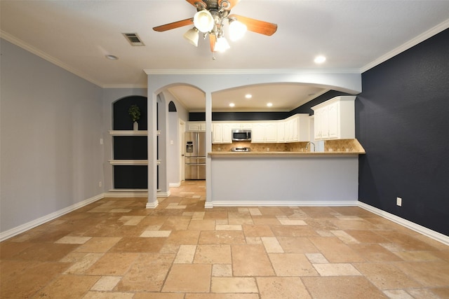 6709 Jay Rd, Hitchcock, TX 77563 - kitchen with appliances with stainless steel finishes, stone tile floors, a ceiling fan, crown molding, and a peninsula