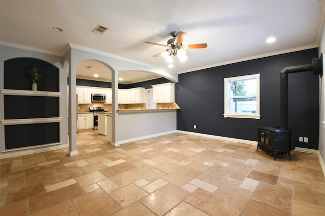 6709 Jay Rd, Hitchcock, TX 77563 - unfurnished living room featuring ceiling fan, stone tile flooring, recessed lighting, a wood stove, and ornamental molding