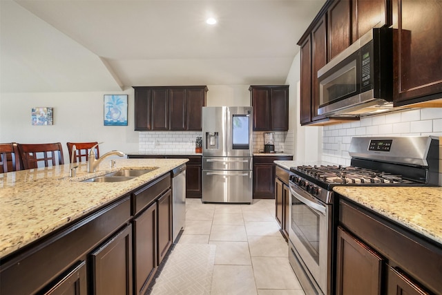 6914 Arcadia Meadow Ct, Richmond, TX 77407 - kitchen with stainless steel appliances, tasteful backsplash, light stone countertops, dark brown cabinetry, and recessed lighting