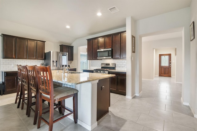 6914 Arcadia Meadow Ct, Richmond, TX 77407 - kitchen with appliances with stainless steel finishes, dark brown cabinetry, plenty of natural light, recessed lighting, and vaulted ceiling