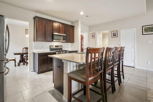 6914 Arcadia Meadow Ct, Richmond, TX 77407 - kitchen with stainless steel appliances, tasteful backsplash, light stone countertops, dark brown cabinetry, and recessed lighting