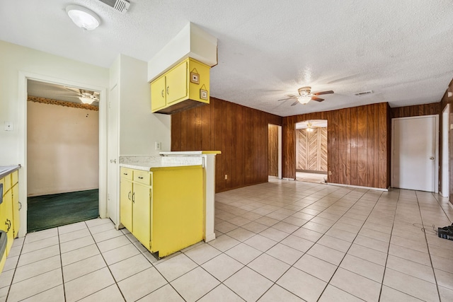 11302 Murr Way, Houston, TX 77048 - kitchen featuring a ceiling fan, wooden walls, a textured ceiling, light countertops, and light tile patterned floors