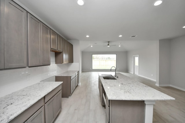 15819 Walnut Leaf Ln, Cypress, TX 77429 - kitchen with recessed lighting, an island with sink, light stone countertops, a ceiling fan, and tasteful backsplash
