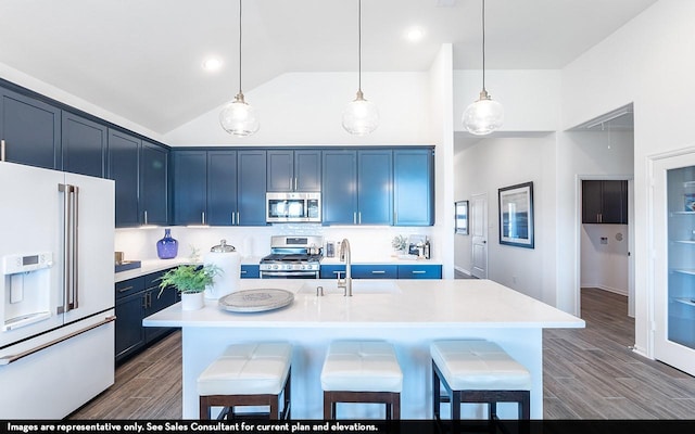 3911 Redbud Ct, Santa Fe, TX 77510 - kitchen featuring appliances with stainless steel finishes, blue cabinetry, a kitchen breakfast bar, light countertops, and dark wood-style floors