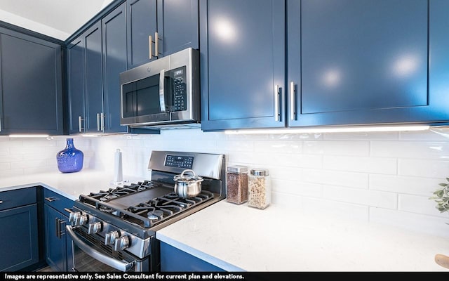 3911 Redbud Ct, Santa Fe, TX 77510 - kitchen with appliances with stainless steel finishes, blue cabinetry, light countertops, and backsplash