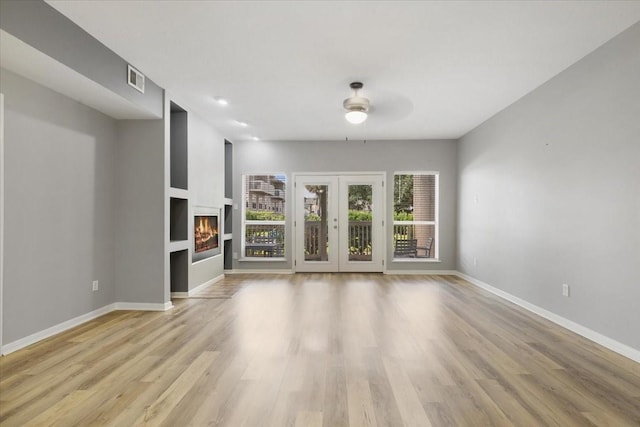 4747 Nasa Pkwy Unit 110, Seabrook, TX 77586 - unfurnished living room with a ceiling fan, light wood finished floors, and a warm lit fireplace