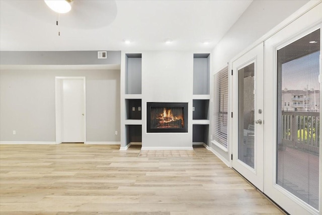 4747 Nasa Pkwy Unit 110, Seabrook, TX 77586 - unfurnished living room featuring light wood finished floors, a lit fireplace, and recessed lighting