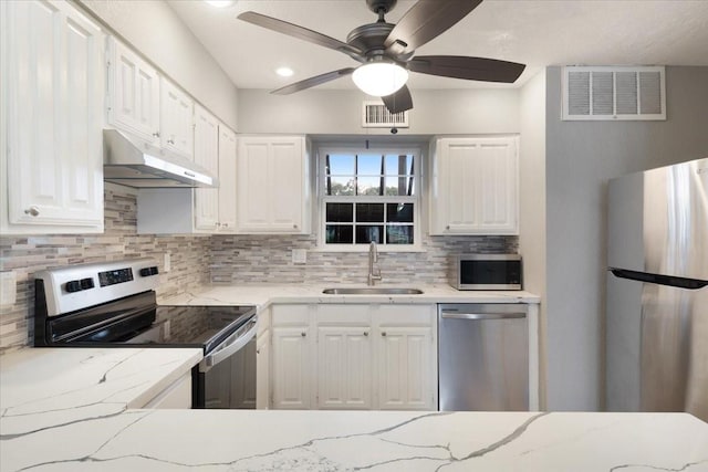 4747 Nasa Pkwy Unit 110, Seabrook, TX 77586 - kitchen featuring appliances with stainless steel finishes, under cabinet range hood, backsplash, and white cabinets