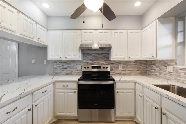 4747 Nasa Pkwy Unit 110, Seabrook, TX 77586 - kitchen featuring stainless steel range with electric stovetop, under cabinet range hood, white cabinetry, ceiling fan, and tasteful backsplash