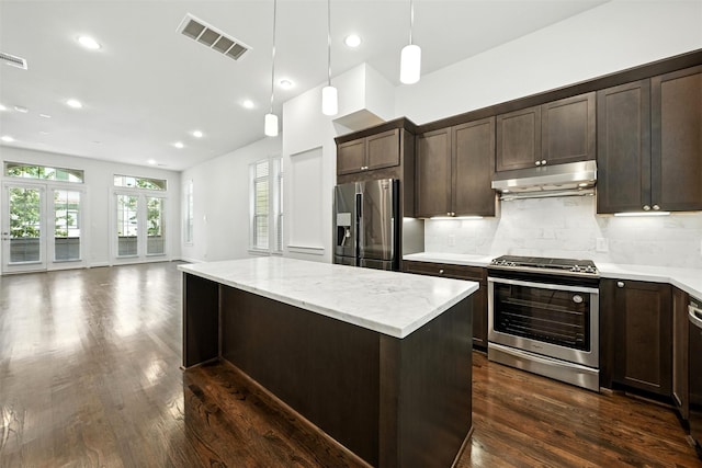 4106 Schuler St, Houston, TX 77007 - kitchen with appliances with stainless steel finishes, under cabinet range hood, dark brown cabinetry, a kitchen island, and recessed lighting