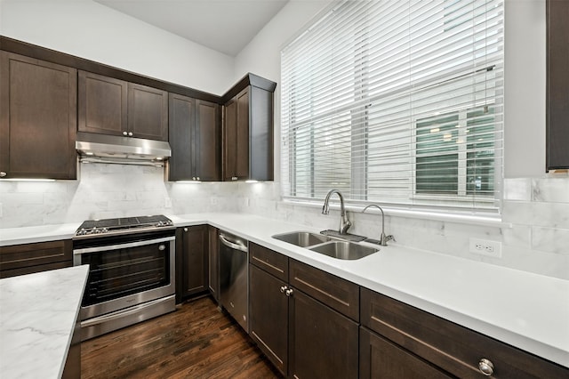 4106 Schuler St, Houston, TX 77007 - kitchen with stainless steel appliances, under cabinet range hood, light countertops, dark brown cabinetry, and backsplash