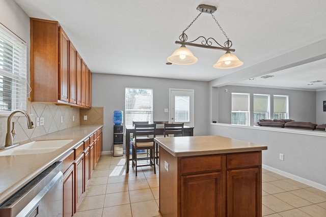 29406 Legends Stone Dr, Spring, TX 77386 - kitchen featuring light tile patterned floors, stainless steel dishwasher, tasteful backsplash, light countertops, and decorative light fixtures