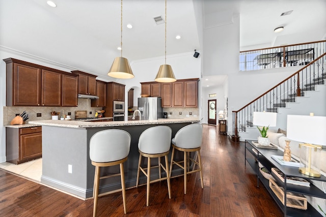 14107 Park Antique Ln, Cypress, TX 77429 - kitchen featuring stainless steel appliances, a high ceiling, under cabinet range hood, decorative backsplash, and pendant lighting