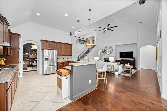 14107 Park Antique Ln, Cypress, TX 77429 - kitchen featuring appliances with stainless steel finishes, arched walkways, high vaulted ceiling, a ceiling fan, and under cabinet range hood