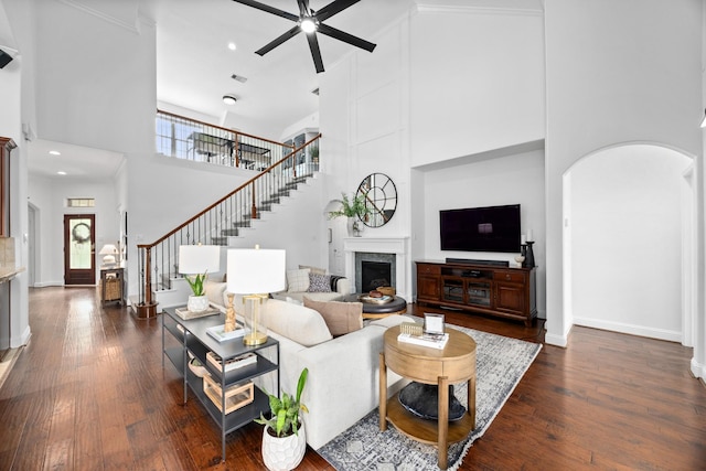 14107 Park Antique Ln, Cypress, TX 77429 - living room featuring a towering ceiling, a ceiling fan, a fireplace, stairway, and arched walkways