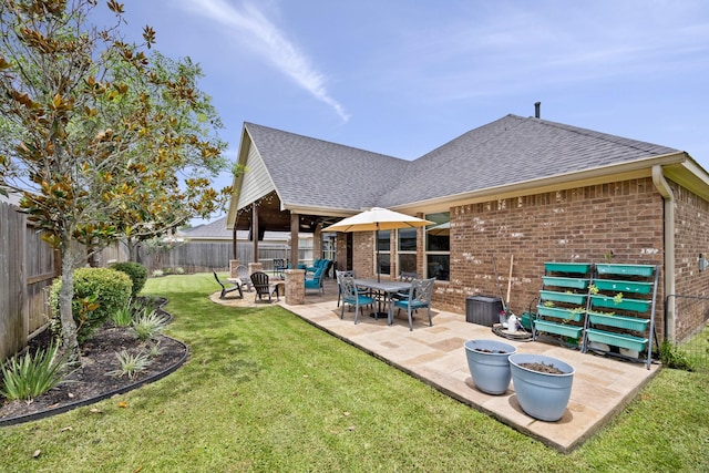 14107 Park Antique Ln, Cypress, TX 77429 - back of house featuring a shingled roof, brick siding, a fenced backyard, and a patio