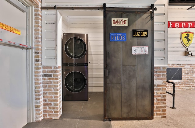 1435 Fm 1463rd Rd Unit C14, Katy, TX 77494 - laundry room featuring stacked washing machine and dryer, a barn door, and brick wall