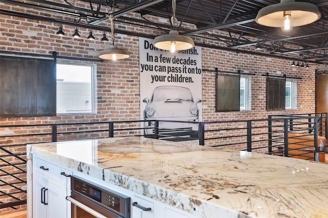 1435 Fm 1463rd Rd Unit C14, Katy, TX 77494 - kitchen featuring brick wall, a barn door, light stone counters, white cabinets, and oven