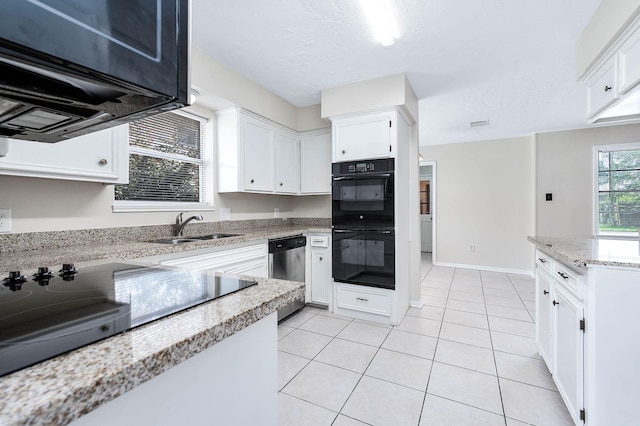 510 Shenandoah Dr, Shenandoah, TX 77381 - kitchen featuring black appliances, white cabinets, light tile patterned floors, light stone counters, and a textured ceiling