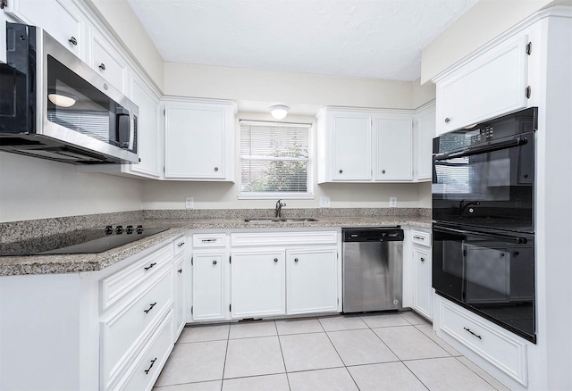 510 Shenandoah Dr, Shenandoah, TX 77381 - kitchen featuring black appliances, white cabinetry, light tile patterned floors, and a textured ceiling