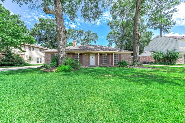 510 Shenandoah Dr, Shenandoah, TX 77381 - view of front of house with a chimney, a front lawn, and brick siding