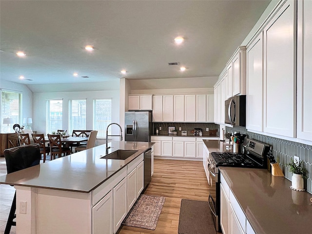 19022 Palizzi Ridge Ln, New Caney, TX 77357 - kitchen with stainless steel appliances, light wood finished floors, recessed lighting, backsplash, and a kitchen island with sink