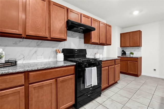 11642 Bodark Valley Ln, Houston, TX 77038 - kitchen with black gas range oven, under cabinet range hood, tasteful backsplash, light stone counters, and brown cabinets