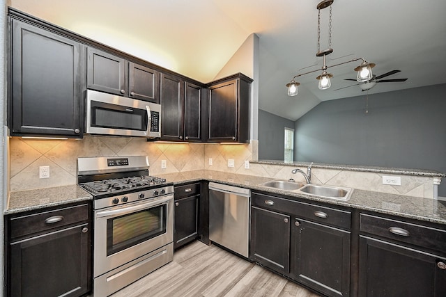 23014 Indigo Prairie Ln, Katy, TX 77493 - kitchen featuring appliances with stainless steel finishes, lofted ceiling, ceiling fan, light wood-style floors, and dark stone counters