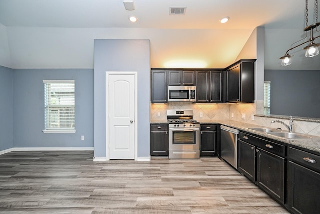 23014 Indigo Prairie Ln, Katy, TX 77493 - kitchen with stainless steel appliances, light wood-style floors, tasteful backsplash, decorative light fixtures, and recessed lighting