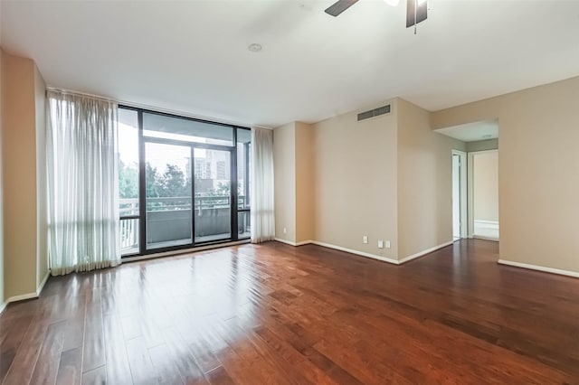 15 Greenway Plz Unit 5C, Houston, TX 77046 - empty room featuring dark wood-type flooring, ceiling fan, and a wall of windows