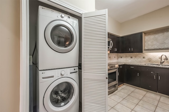 15 Greenway Plz Unit 5C, Houston, TX 77046 - laundry room featuring stacked washer and clothes dryer and light tile patterned floors