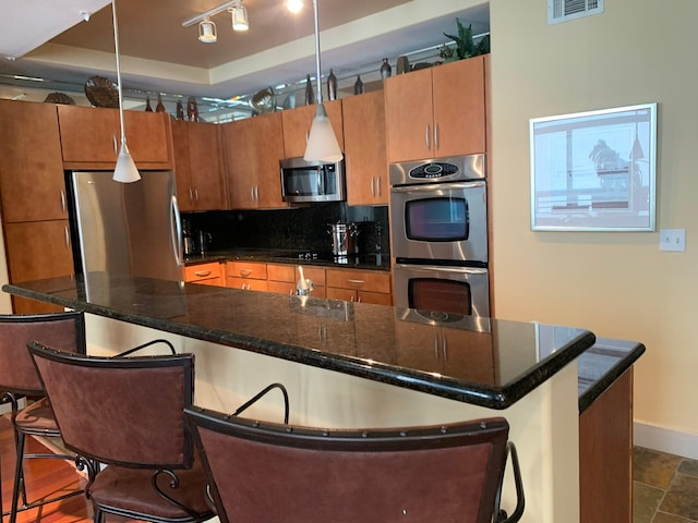 1901 Post Oak Unit 302, Houston, TX 77056 - kitchen featuring stainless steel appliances, backsplash, a breakfast bar area, and dark countertops