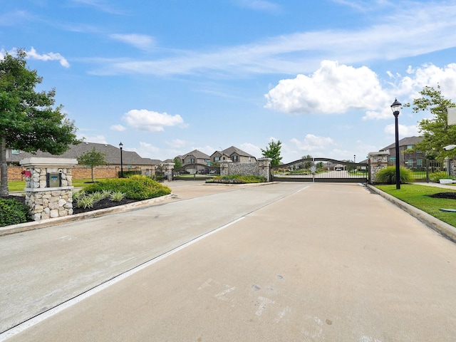 12519 Crathie Dr, Humble, TX 77346 - view of concrete road featuring street lighting, a gate, a residential view, and curbs