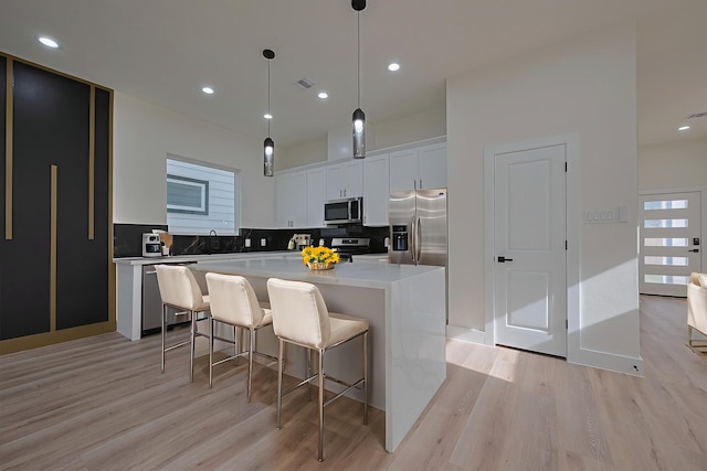 2422 Dalview St, Houston, TX 77091 - kitchen with stainless steel appliances, light wood-type flooring, a center island, tasteful backsplash, and recessed lighting