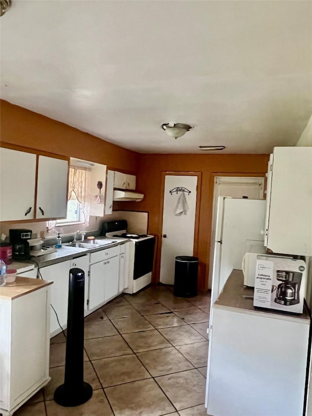 1410 Caplin St, Houston, TX 77022 - kitchen featuring white appliances, under cabinet range hood, white cabinetry, and light tile patterned floors