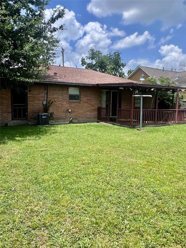 1410 Caplin St, Houston, TX 77022 - rear view of house featuring brick siding, a yard, and roof with shingles