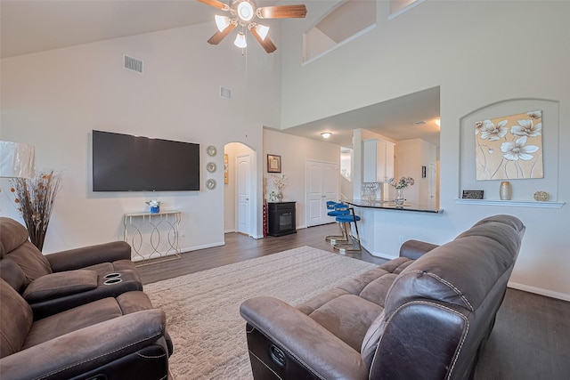 10434 Lake Of The Ozarks Dr, Humble, TX 77396 - living room featuring arched walkways, ceiling fan, dark wood-style floors, and a towering ceiling