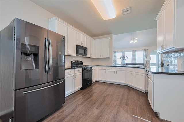 10434 Lake Of The Ozarks Dr, Humble, TX 77396 - kitchen featuring black appliances, dark wood finished floors, dark countertops, and decorative backsplash
