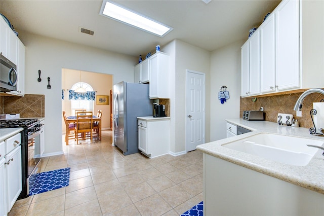 19238 Ashford Square St, Tomball, TX 77375 - kitchen featuring appliances with stainless steel finishes, backsplash, white cabinetry, and light tile patterned floors