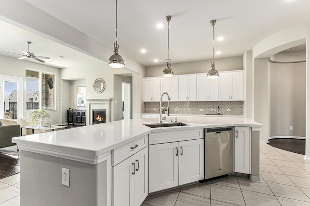 13603 Sandford Meadow Ln, Cypress, TX 77429 - kitchen featuring stainless steel dishwasher, open floor plan, an island with sink, tasteful backsplash, and light countertops